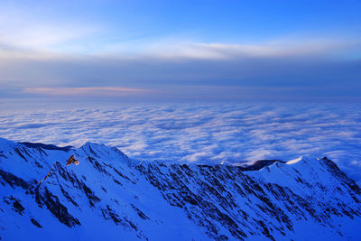 Scenic view of snowcapped mountains against blue sky