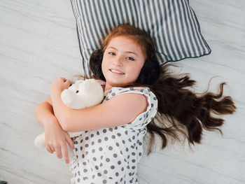 Portrait of happy girl lying on floor at home