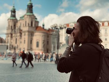 Side view of woman photographing with camera