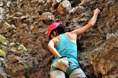 Low angle view of woman climbing on rock