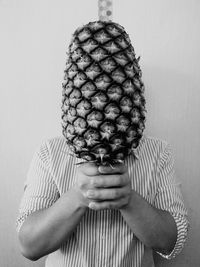 Close-up of a cropped hand holding umbrella against white background
