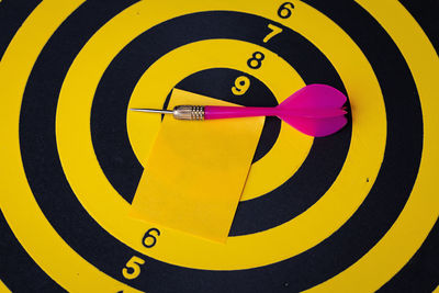 Close-up of blank paper and dart on sports target