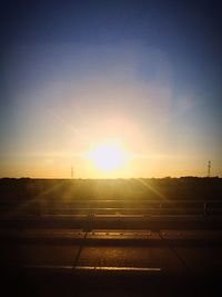 Empty road against sky during sunset