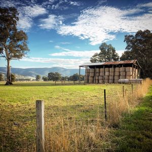 Wooden fence on field against sky
