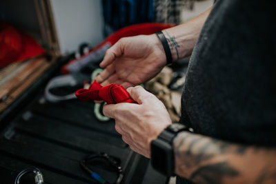 Man tying knot in red safety rope