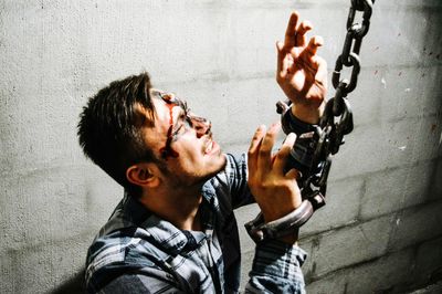 Injured man with hand cuffed by wall