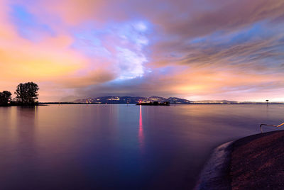 Scenic view of sea against dramatic sky during sunset