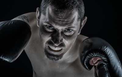 Portrait of boxer against black background