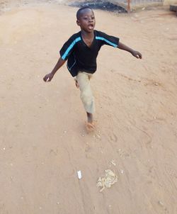 Full length of happy boy running on beach