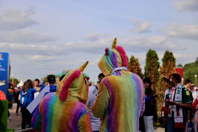 Rear view of people in traditional clothing standing against sky