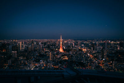 Illuminated city against sky at night