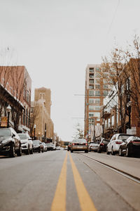 View of city street and buildings against sky