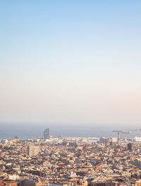 Aerial view of buildings in city against clear sky