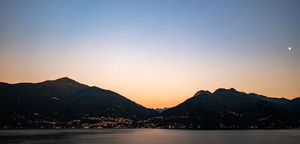 Scenic view of silhouette mountains against clear sky during sunset