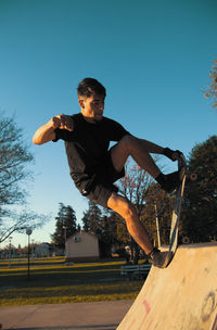 Side portrait of skateboarder doing a trick