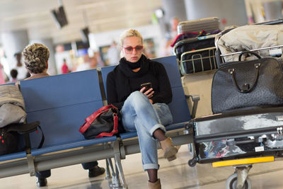 Full length of woman sitting at airport