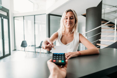 Beautiful woman paying in shop through contact less credit card. shopping