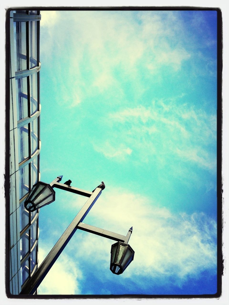 low angle view, sky, blue, cloud - sky, transfer print, auto post production filter, cloud, lighting equipment, cloudy, street light, day, built structure, no people, outdoors, metal, architecture, pole, building exterior, communication, technology