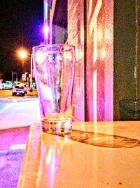 Close-up of beer glass on table at night