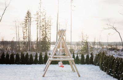 Snow covered kids climbing frame and swing set in a garden at home