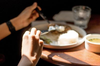 Close-up of hand holding bowl of food