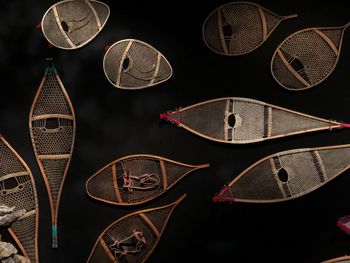 Directly above shot of various snowshoes on black background