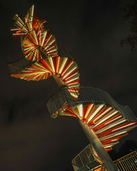 Low angle view of illuminated staircases against sky at night