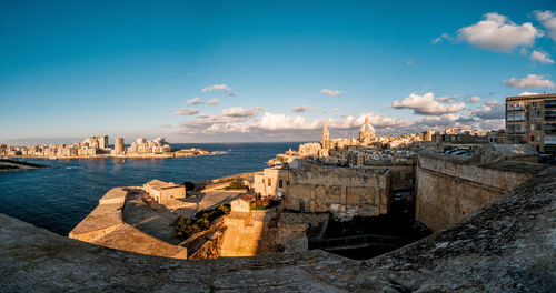 Panoramic view of sea and buildings against sky