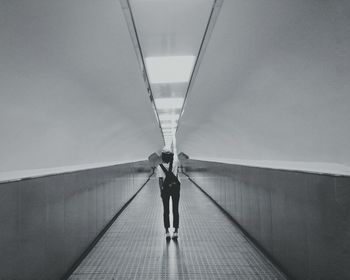 Rear view of woman walking on bridge