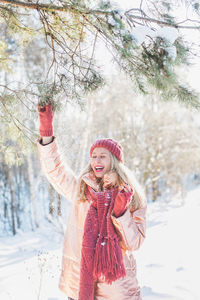 Portrait of happy girl standing against snow