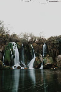 Scenic view of waterfall against sky