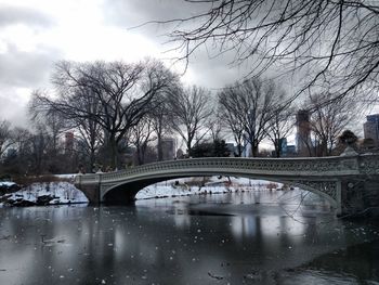 Bridge over river in city during winter