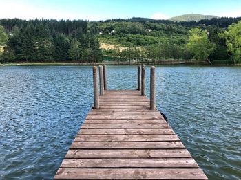 Wooden jetty on pier over lake against sky