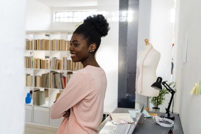 Fashion designer smiling while standing at home office