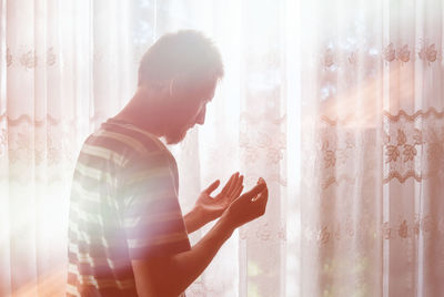 Side view of man looking at window