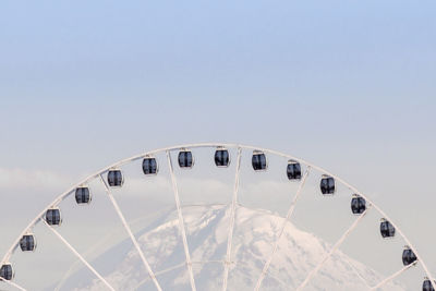 Low angle view of ferris wheel against mount rainier