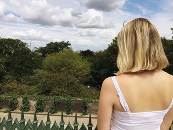 Rear view of woman against cloudy sky