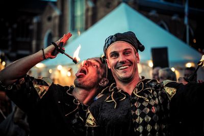 Portrait of smiling fire-eater in costume with friend