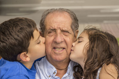 Boy and girl kissing grandfather