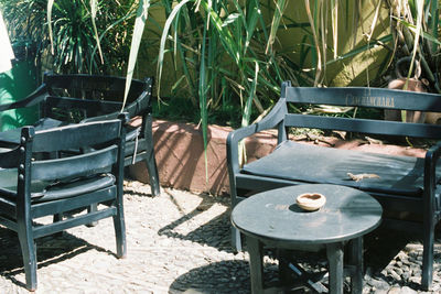 Empty chairs and table in park during sunny day