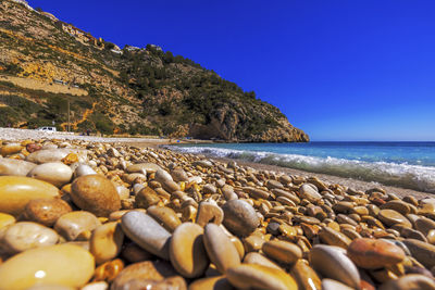 Rocks on beach against clear sky