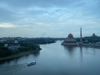 River amidst buildings in city against sky