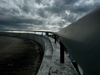 Rear view of man walking on bridge against sky