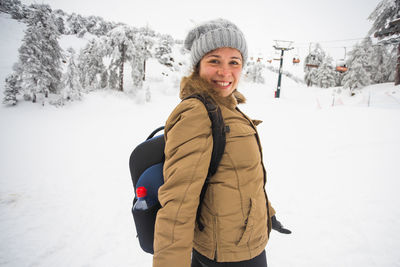 Portrait of smiling woman standing in snow