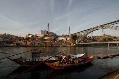 Boats in river against sky in city