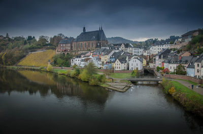 River amidst buildings in town against sky