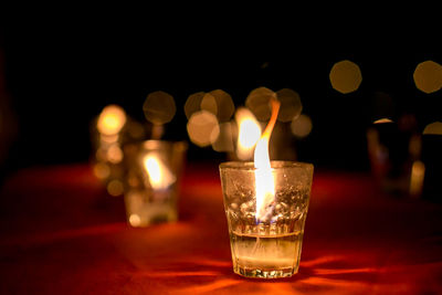Close-up of illuminated tea light candles on table