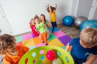 Rear view of people playing with multi colored balloons