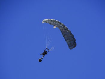 Low angle view of kite flying against clear blue sky