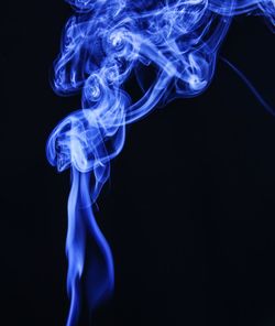 Close-up of blue smoke against black background